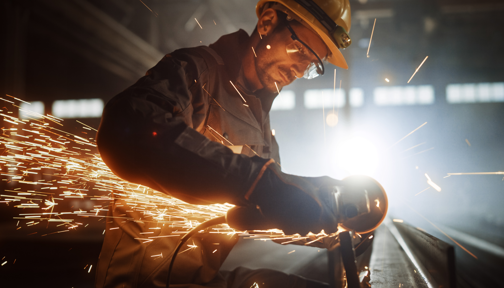 Worker grinding metal with sparks flying